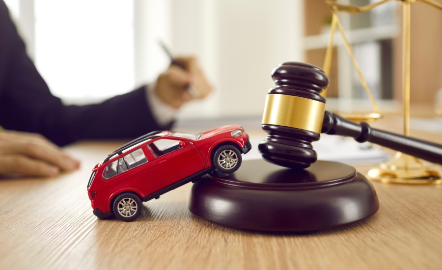 A car model and judge's hammer on a wooden desk