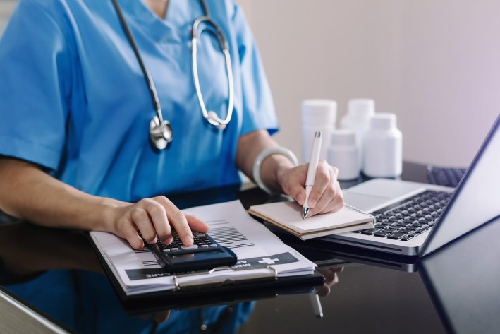 A doctor calculates medical costs at a hospital