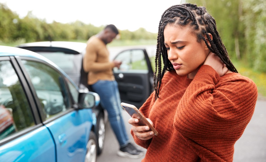 A man and a woman next to their cars after a car accident