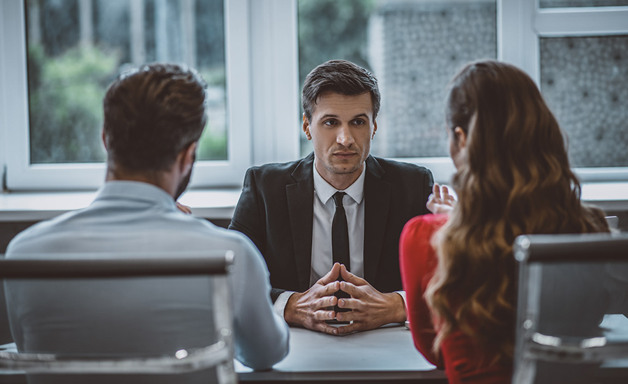 A couple preparing for a Green Card marriage interview at a lawyer's office