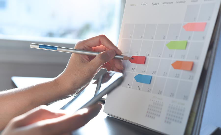 A woman marks dates in a planner