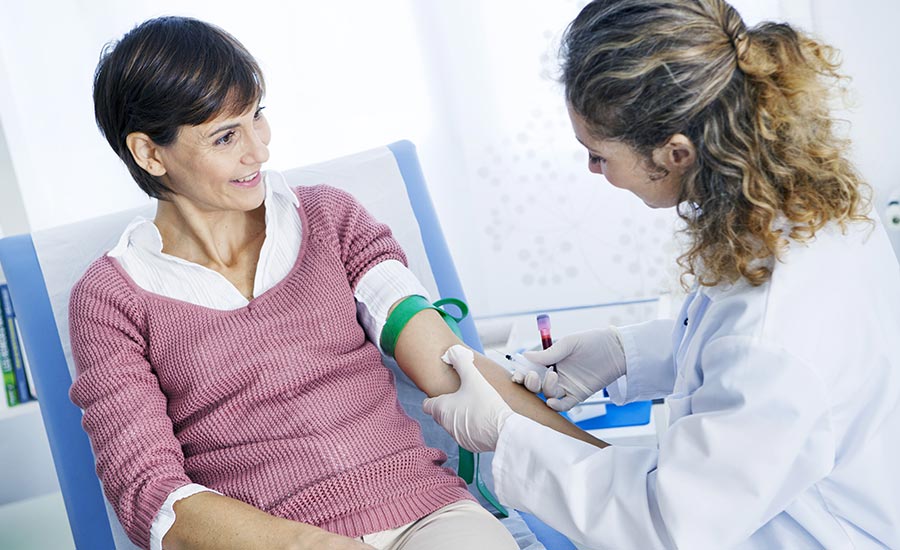 A female phlebotomist draws blood from a woman