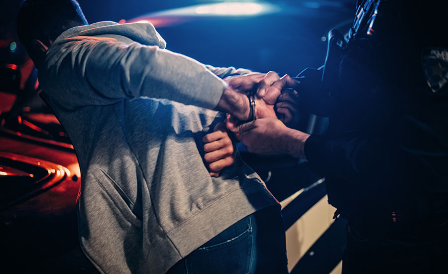 Two police officers aiming at a suspect in the street