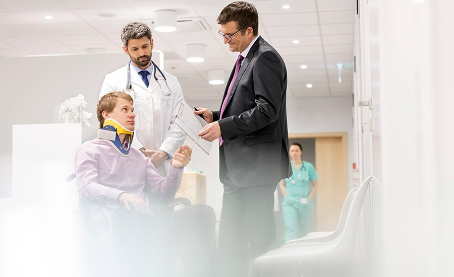 A patient with a doctor and a lawyer talking in a hospital corridor