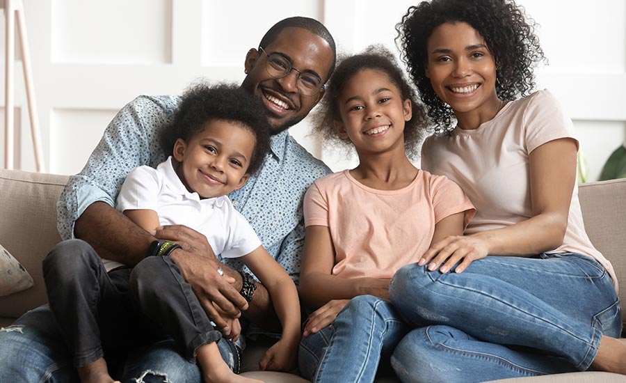 Happy parents with two children sitting on a couch