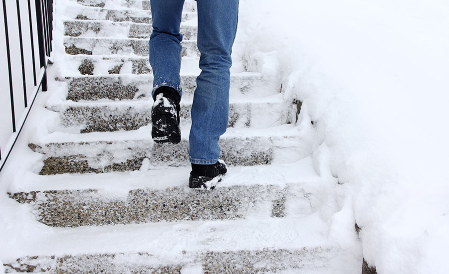 A man climbing up a snow-covered staircase