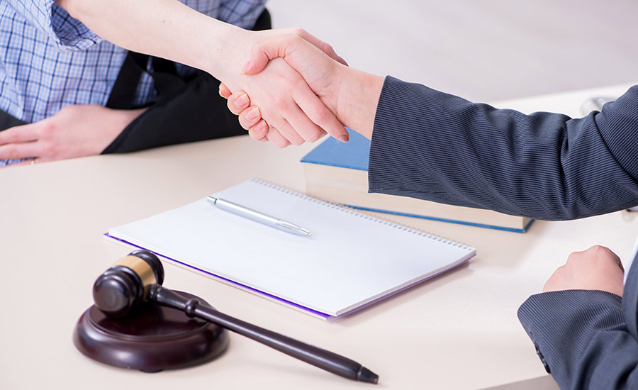 An injured construction worker shaking hands with a lawyer