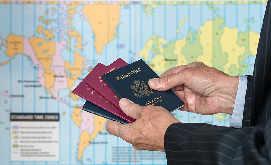 A ma with several different passports in front of a world map​