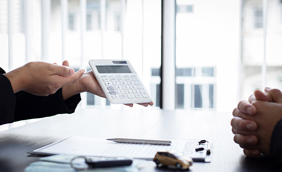 A person showing compensation amounts on a calculator
