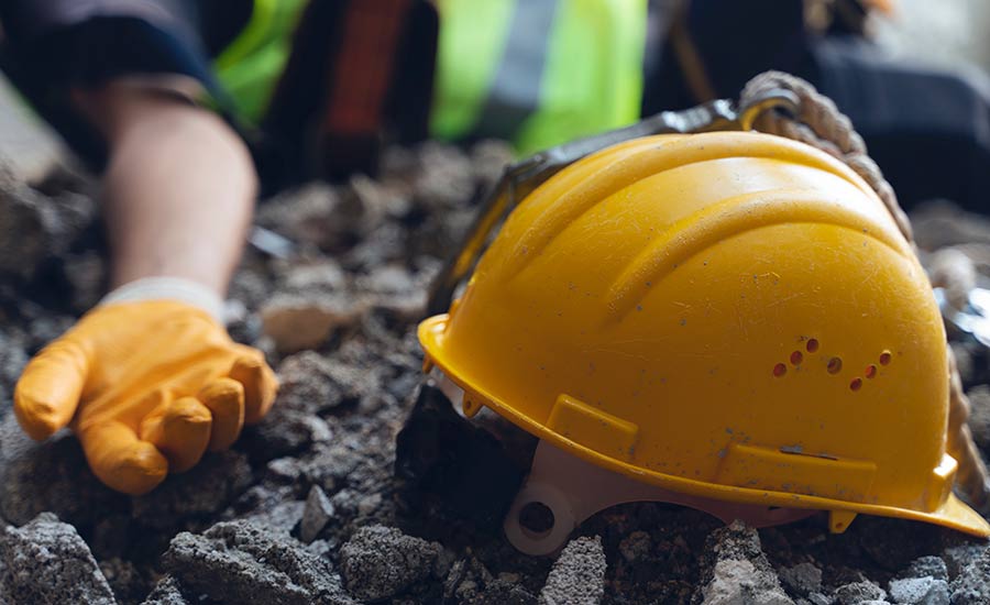 An injured worker and a hard hat on a construction site​