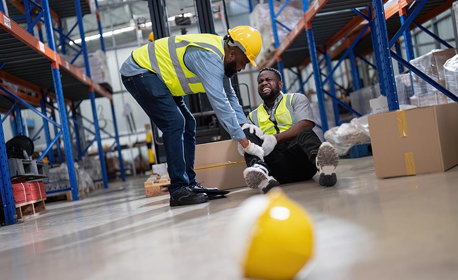 A worker helping a co-worker who was injured in a forklift accident​