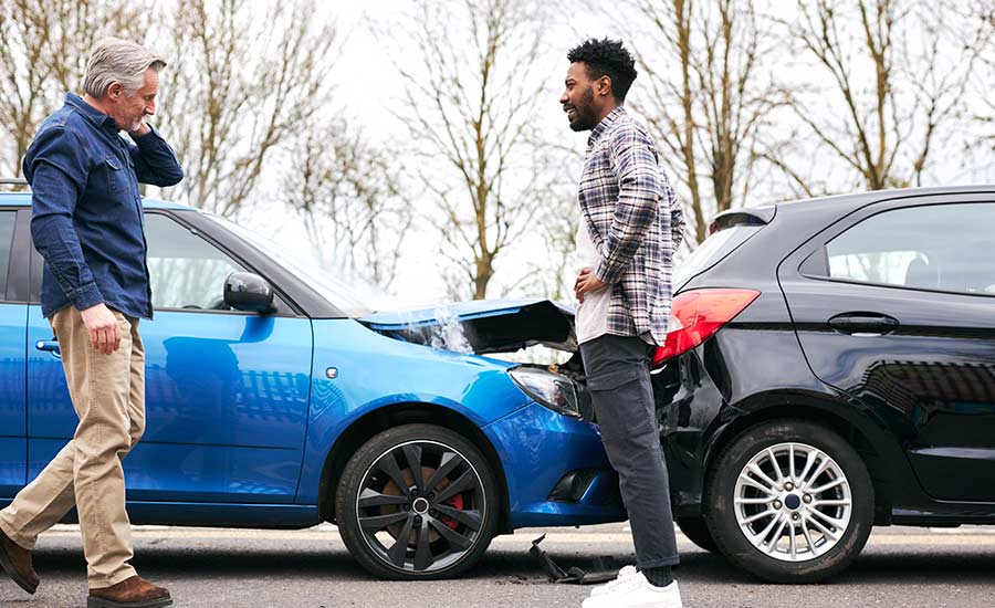 Two men looking at their vehicles after a rear-end collision​