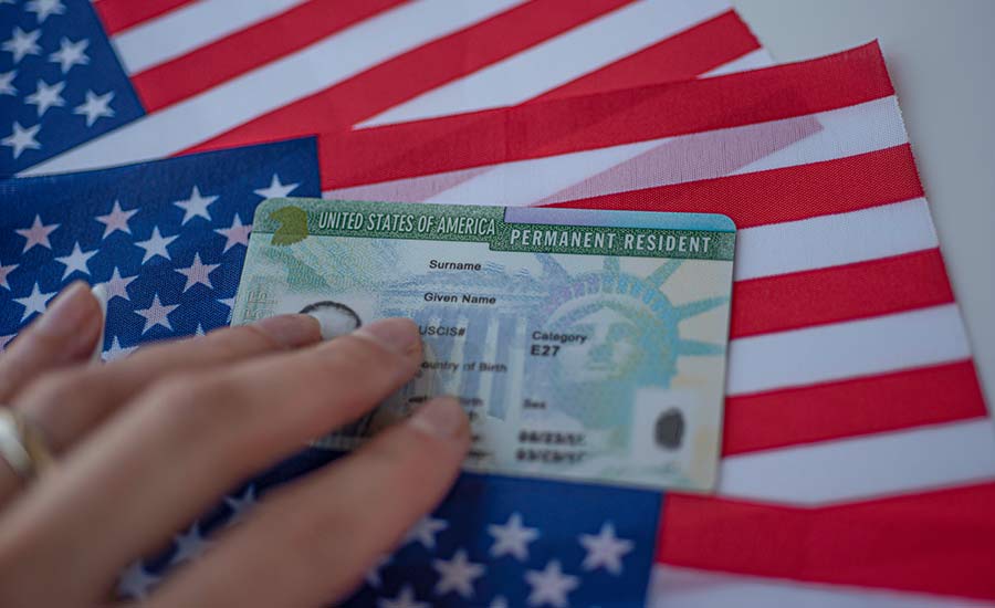 A Green Card and the U.S. flag​