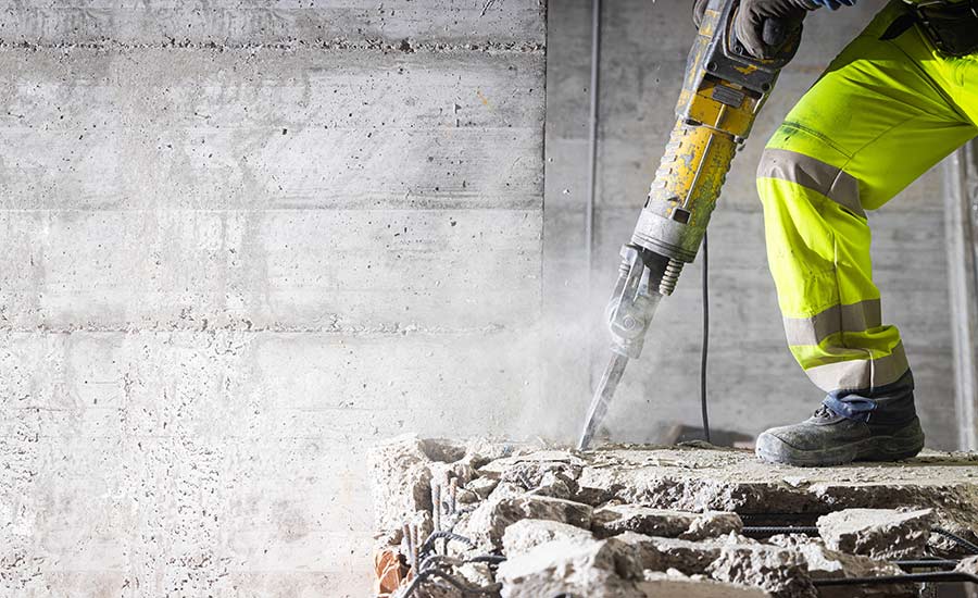 A construction worker using a heavy duty jackhammer​