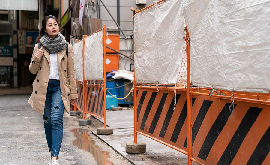 A female pedestrian passing by a construction site​