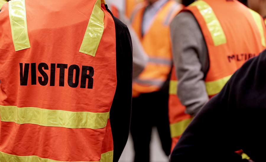 Construction site visitors wearing orange vests​