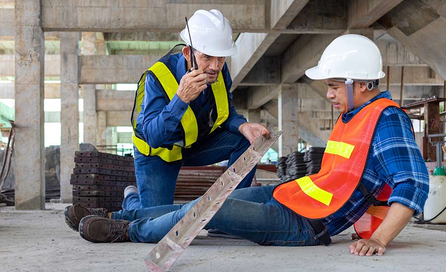 A worker helps an injured colleague after a construction accident​