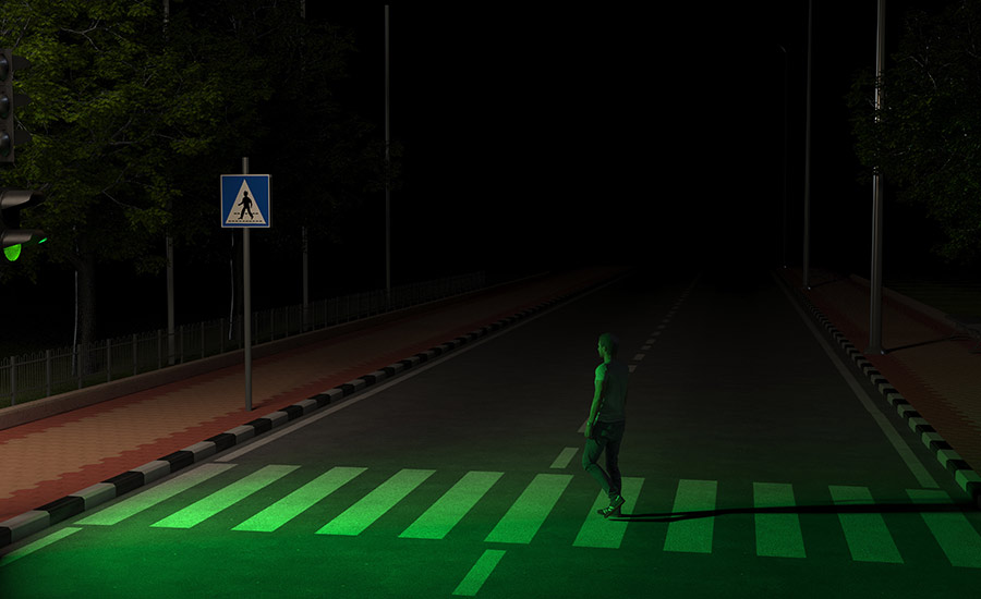 A pedestrian crossing a dark road during the night​