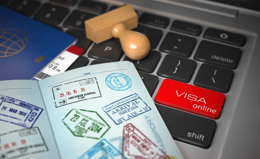 A passport with visa stamps and laptop